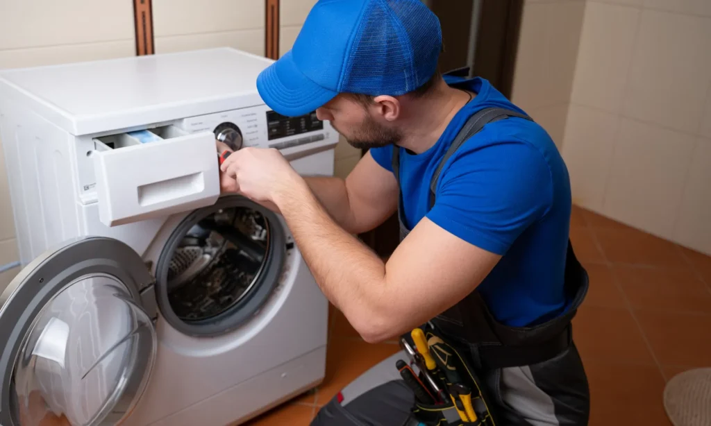 a person fixing a washing machine in a bathroom