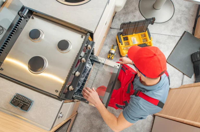 a person in a red hat is working on an oven.