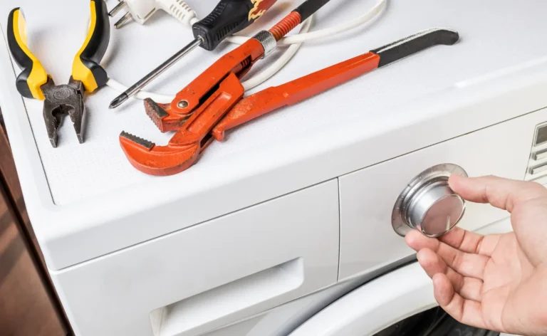 a person is using tools to fix a washing machine.