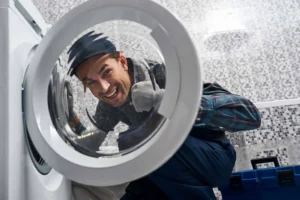 A person is smiling in front of a washing machine.